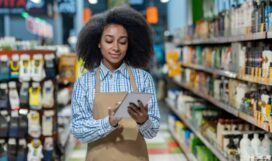 Female,Employee,In,A,Retail,Store,Aisle,,Using,A,Tablet
